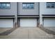 A view of garage doors on modern townhouses, highlighting the paved driveway and meticulous landscaping in front of the homes at 433 Nathaniel Way # Brx0033, Charlotte, NC 28213