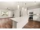 A modern kitchen features stainless steel appliances, a center island with white countertop, and pendant lighting at 437 Nathaniel Way # Brx0034, Charlotte, NC 28213