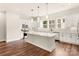 A white kitchen features a large island and stainless steel appliances, modern lighting at 437 Nathaniel Way # Brx0034, Charlotte, NC 28213