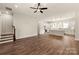 An open concept living room showcases hardwood floors, a ceiling fan, and an adjacent modern kitchen at 437 Nathaniel Way # Brx0034, Charlotte, NC 28213