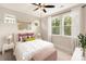 A stylish bedroom featuring many windows for natural light with white trim and a ceiling fan at 441 Nathaniel Way # Brx0035, Charlotte, NC 28213