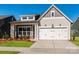 Gray exterior with white trim, stone accents, and a two-car garage at 1110 Lowland Way, Waxhaw, NC 28173