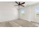 Sunlit bedroom with carpet, ceiling fan, and a view of the green field outside the window at 4122 Old Monroe Marshville Rd, Wingate, NC 28174