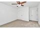 Spacious bedroom with neutral carpet, ceiling fan, fresh white paint, and multiple doors at 4122 Old Monroe Marshville Rd, Wingate, NC 28174