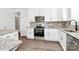 This modern kitchen boasts white cabinets, stainless steel appliances, granite countertops, and a decorative tile backsplash at 4122 Old Monroe Marshville Rd, Wingate, NC 28174