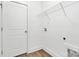 Clean laundry area with door, washer hookups, overhead storage shelf, and modern flooring at 4122 Old Monroe Marshville Rd, Wingate, NC 28174