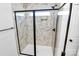 Modern shower with glass door, marbled tile, and black hardware in a newly constructed home at 4122 Old Monroe Marshville Rd, Wingate, NC 28174
