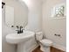 Well-lit half bathroom featuring a pedestal sink, black faucet, toilet, and small window for natural light at 428 Nathaniel Way # Brx0044, Charlotte, NC 28213
