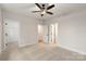 Inviting bedroom showcasing soft carpet, neutral walls, a ceiling fan, and doorways to a closet and en suite bath at 428 Nathaniel Way # Brx0044, Charlotte, NC 28213