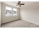 Well-lit bedroom features neutral carpet, two windows with backyard views, and a ceiling fan at 428 Nathaniel Way # Brx0044, Charlotte, NC 28213