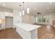 Open floor plan featuring a kitchen with an island and a living area with an open design and modern lighting at 428 Nathaniel Way # Brx0044, Charlotte, NC 28213