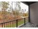 Cozy balcony featuring wood-look flooring and a black metal railing overlooking a wooded area at 432 Nathaniel Way # Brx0043, Charlotte, NC 28213