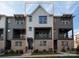 Detailed view of townhome exterior showing a white vertical siding, brick facade, and dark accents at 436 Nathaniel Way # Brx0042, Charlotte, NC 28213