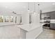 Modern kitchen with gray cabinets, a quartz island, and open view to the living room at 436 Nathaniel Way # Brx0042, Charlotte, NC 28213