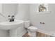 Modern half-bath with a white sink, toilet, and minimalist design with a small window at 440 Nathaniel Way # Brx0041, Charlotte, NC 28213