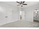 Carpeted bedroom featuring a ceiling fan and a doorway leading to an ensuite bathroom at 440 Nathaniel Way # Brx0041, Charlotte, NC 28213