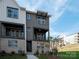 This is a modern three-story townhome with brick accents, multiple balconies, and professional landscaping at 440 Nathaniel Way # Brx0041, Charlotte, NC 28213