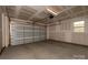 This is a spacious unfinished garage with a roll-up door, presenting a blank canvas for customization and ample storage at 440 Nathaniel Way # Brx0041, Charlotte, NC 28213