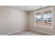 Bright bedroom features neutral carpet, light walls, and a view of the neighborhood through a large window at 4436 Moxie Way, Charlotte, NC 28215