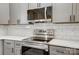 Modern stainless steel range and microwave with white countertops and gray cabinetry at 751 White Jenkins Rd, Bessemer City, NC 28016