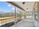 Covered porch featuring black railing and brick base with a view of the treelined backyard at 751 White Jenkins Rd, Bessemer City, NC 28016