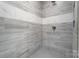 A close-up of the tiled shower space showcasing the rainfall shower head, faucet hardware and mosaic tile floor at 751 White Jenkins Rd, Bessemer City, NC 28016