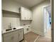 Functional laundry room featuring ample counter space, modern cabinets, sink, and a doorway at 139 Poplar Grove Rd, Mooresville, NC 28117