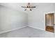 Spacious bedroom with grey carpet, ceiling fan, and access to hallway at 2610 Henry Baucom Rd, Monroe, NC 28110