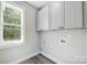 Bright laundry room with gray cabinets and a window overlooking the backyard at 2610 Henry Baucom Rd, Monroe, NC 28110