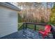 Back deck with red chair and wooded backyard view at 7457 Waterleaf Ct, Stanley, NC 28164