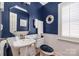 Stylish powder room with white pedestal sink and blue walls at 7457 Waterleaf Ct, Stanley, NC 28164