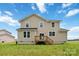 Two story home with tan vinyl siding, deck, and grass lawn under sunny blue sky at 1034 Heath Helms Rd, Monroe, NC 28110