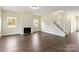 Spacious living room featuring hardwood floors, a cozy fireplace, and a staircase leading to the upper level at 1034 Heath Helms Rd, Monroe, NC 28110