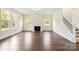 Bright living room with a modern fireplace, hardwood floors, and large windows filling the space with natural light at 1034 Heath Helms Rd, Monroe, NC 28110