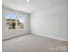 Empty bedroom featuring a window showing a home across the street, carpeted floors, and white walls at 1051 Bull Dog Ln, Wingate, NC 28174