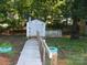 Backyard with a white shed, surrounded by greenery, offering a peaceful and private outdoor retreat at 112 S Cardinal Dr, New London, NC 28127