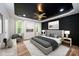 Virtually staged main bedroom with a gray bed, dark ceiling, and large windows at 312 General As Johnston St, Stanley, NC 28164