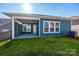 Home's exterior featuring a teal-colored house with a covered patio at 1010 Lowland Way, Waxhaw, NC 28173