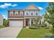 Two-story home with gray siding and brick accents, two-car garage at 129 Eden Ave, Mooresville, NC 28115