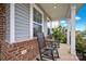 Inviting front porch with rocking chairs, brick facade, and landscaping at 129 Eden Ave, Mooresville, NC 28115