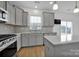 Modern kitchen with gray cabinets, island, and stainless steel appliances at 129 Eden Ave, Mooresville, NC 28115