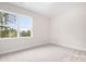 Bright bedroom featuring neutral carpet, base trim, and a large window with outside views at 332 Shinnville Rd, Mooresville, NC 28115