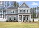 Charming two-story home featuring a welcoming front porch, gray siding, and beautifully landscaped yard at 332 Shinnville Rd, Mooresville, NC 28115