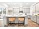 Modern kitchen design with an island, barstool seating, white cabinets, stainless steel appliances, and stylish pendant lighting at 332 Shinnville Rd, Mooresville, NC 28115