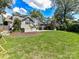 Large green backyard with a view of the exterior; the yard has mulch with grassy areas, patio, and other homes at 2110 E 5Th St, Charlotte, NC 28204