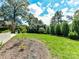 A backyard with a basketball hoop and light gray paved patio leads to a grassy yard covered with mulch at 2110 E 5Th St, Charlotte, NC 28204