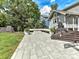 Backyard patio with a gray brick layout has a chalkboard, trees, and stairs that lead to a deck with metal wire railing at 2110 E 5Th St, Charlotte, NC 28204