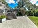 Backyard patio with gray pavers leads to a wooden deck and stairs; basketball hoop is in the background at 2110 E 5Th St, Charlotte, NC 28204