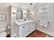 Bright bathroom featuring a double vanity with white cabinets, arched mirrors, and modern sconces at 2110 E 5Th St, Charlotte, NC 28204