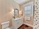 Elegant bathroom with a white vanity, marble countertop, decorative mirror, and stylish wallpaper at 2110 E 5Th St, Charlotte, NC 28204